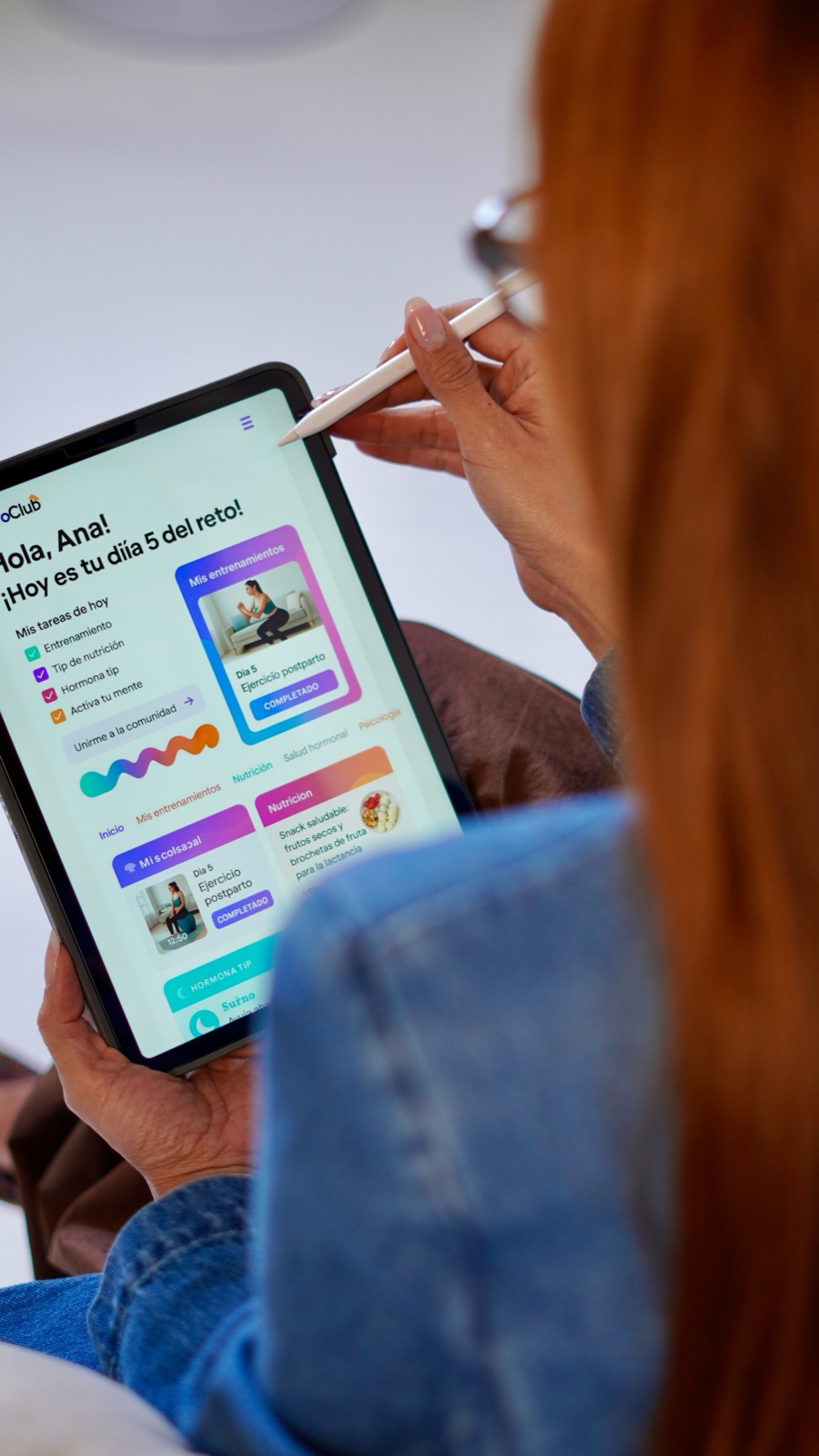 Manos sosteniendo tablet con la plataforma del Reto 21 D&iacute;as de la Dra. Paola S&aacute;nchez